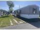 Exterior view of the manufactured home on a sunny day showing the gravel driveway at 1242 Carrie Bell Ln, Myrtle Beach, SC 29577