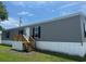 Charming manufactured home with gray siding, black shutters, and a wooden porch with stairs at 1242 Carrie Bell Ln, Myrtle Beach, SC 29577