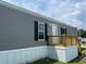 Exterior view of charming manufactured home with inviting wooden deck and stairs at 1242 Carrie Bell Ln, Myrtle Beach, SC 29577