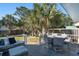 Inviting back deck features a dining set, comfortable seating and mature palms in the backyard at 1415 Edge Dr., North Myrtle Beach, SC 29582