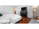 A primary bedroom leading to the en suite bathroom, tv over a chest of drawers, and wood flooring at 1415 Edge Dr., North Myrtle Beach, SC 29582