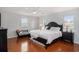 A primary bedroom with a black bed frame, wood flooring, ceiling fan and natural light at 1415 Edge Dr., North Myrtle Beach, SC 29582