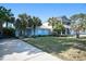 Charming blue home with well-manicured lawn, mature palm trees, and a long driveway at 1415 Edge Dr., North Myrtle Beach, SC 29582