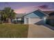 Charming blue house featuring an attached garage, green lawn, and palm tree at 1415 Edge Dr., North Myrtle Beach, SC 29582