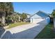 Charming blue house featuring an attached garage, long driveway, and palm trees at 1415 Edge Dr., North Myrtle Beach, SC 29582