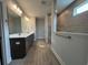 Bathroom featuring a dual sink vanity with granite countertops and a tiled shower at 1430 Crested Iris Way, North Myrtle Beach, SC 29582