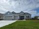 Charming two-story home with blue siding, dual garage doors, and a well-manicured front lawn at 1430 Crested Iris Way, North Myrtle Beach, SC 29582