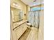 Bright bathroom featuring a granite vanity top, decorative mirror and shower with floral curtain at 144 Puffin Dr. # 1-A, Pawleys Island, SC 29585