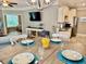 Dining room with wooden table set with coastal themed plates, open to kitchen and living areas at 144 Puffin Dr. # 1-A, Pawleys Island, SC 29585