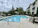 Community pool featuring a wheelchair lift, lounge chairs, and beautifully landscaped grounds at 144 Puffin Dr. # 1-A, Pawleys Island, SC 29585