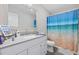 Bright bathroom features a vanity, large mirror, and shower with blue ocean-themed curtain at 1720 Horry St., Conway, SC 29526