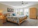 Bright main bedroom features a ceiling fan, bay windows, carpet floors and a large bed at 1755 Fairbanks Dr., Conway, SC 29526