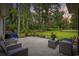 Inviting stone patio with comfortable seating and views of the expansive, tree-lined backyard at 180 Waterhall Dr., Murrells Inlet, SC 29576