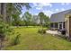 Spacious backyard featuring a well-manicured lawn, mature trees, and a cozy patio area for outdoor enjoyment at 180 Waterhall Dr., Murrells Inlet, SC 29576