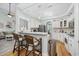 Modern kitchen with white cabinetry, hardwood floors, breakfast bar and an open layout to the living area at 180 Waterhall Dr., Murrells Inlet, SC 29576