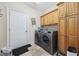 Well-equipped laundry room with washer, dryer, storage cabinets, and access door at 180 Waterhall Dr., Murrells Inlet, SC 29576