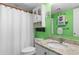 Bright and quirky bathroom with green walls, a granite countertop, and a shower with a curtain at 201 S Ocean Blvd., North Myrtle Beach, SC 29582