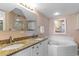 Spa-like bathroom featuring double sinks, granite countertop, large mirror, and a jacuzzi tub at 201 S Ocean Blvd., North Myrtle Beach, SC 29582