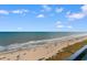 Serene ocean view with a sandy beach and clear blue skies, offering a peaceful and inviting atmosphere at 201 S Ocean Blvd., North Myrtle Beach, SC 29582