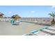 Spacious community pool deck with comfortable lounge chairs and tables overlooking the water at 201 S Ocean Blvd., North Myrtle Beach, SC 29582