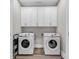 Laundry room featuring two Samsung washing machines and upper cabinets for storage at 226 9Th Ave. S, North Myrtle Beach, SC 29582