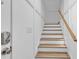 Well-lit stairway featuring wooden steps and a white handrail at 226 9Th Ave. S, North Myrtle Beach, SC 29582