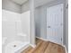 Bathroom features a clean, white shower stall, wood-look flooring, and white door at 229 Duchess Ct., Myrtle Beach, SC 29588