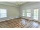 Spacious bedroom with hardwood floors, ceiling fan, and natural light from large windows at 232 Palm Cove Circle, Myrtle Beach, SC 29588