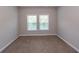 Bright bedroom with neutral walls, plush carpet, and natural light from two windows at 232 Palm Cove Circle, Myrtle Beach, SC 29588