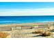 Scenic view of a sandy beach with wooden fencing, clear blue water, and a cloudless sky, perfect for relaxation at 2404 N Ocean Blvd. # 635, Myrtle Beach, SC 29577