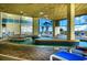 Spacious indoor pool with tile flooring, lounge chairs, large windows with palm tree and ocean views at 2404 N Ocean Blvd. # 635, Myrtle Beach, SC 29577