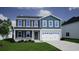 Charming two-story home with a well-maintained lawn, attached two car garage, and classic architectural details at 246 Mayflower Dr., Calabash, NC 28467