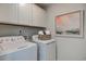 Convenient laundry room with white washer, dryer, upper cabinets, and wall art at 246 Mayflower Dr., Calabash, NC 28467