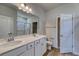 Bathroom featuring a double vanity sink with white cabinetry, large mirror, and a walk-in shower at 250 Mayflower Dr., Calabash, NC 28467