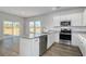 Bright kitchen featuring white cabinets, stainless steel appliances, and a granite-topped island at 250 Mayflower Dr., Calabash, NC 28467