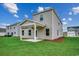 Backyard with covered porch, green grass, and fresh landscaping at 261 Mayflower Dr., Calabash, NC 28467