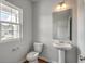 Clean, minimalist bathroom with a pedestal sink, and ample natural light at 261 Mayflower Dr., Calabash, NC 28467