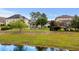 Spacious backyard featuring a covered patio, pergola, and lush greenery with waterfront view at 274 Avenue Of The Palms, Myrtle Beach, SC 29579
