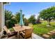 Charming backyard patio with a wooden table and chairs, an umbrella, and view of the manicured lawn at 274 Avenue Of The Palms, Myrtle Beach, SC 29579