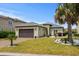 Charming single-story home featuring a well-manicured lawn, brown two-car garage, and tasteful landscaping at 274 Avenue Of The Palms, Myrtle Beach, SC 29579