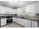 Bright kitchen features white cabinets, tile backsplash, stainless appliances, and gray granite countertops at 274 Avenue Of The Palms, Myrtle Beach, SC 29579