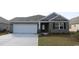 Charming single-story home features brick accents, attached two-car garage, and well-maintained lawn at 309 Glacier Way, Conway, SC 29526