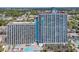 Aerial view of a condo building, showcasing its pool, balconies, and proximity to surrounding areas at 3000 N Ocean Blvd. # 220, Myrtle Beach, SC 29577
