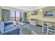 Comfortable living room features a blue sofa, a balcony with views, and beach-themed decor at 3000 N Ocean Blvd. # 220, Myrtle Beach, SC 29577