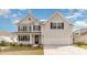 Charming two-story home featuring light gray siding, black shutters, and an attached two-car garage at 341 Glacier Way, Conway, SC 29526