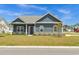 Charming single-story home with blue siding, brick foundation, lush lawn, and professionally landscaped front yard at 383 Hayloft Circle, Conway, SC 29526