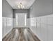 Bright foyer with wood-look flooring, wainscoting, and a stylish chandelier at 383 Hayloft Circle, Conway, SC 29526