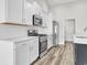 Modern kitchen with stainless steel appliances, white cabinets and wood-style plank flooring at 383 Hayloft Circle, Conway, SC 29526