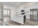 Kitchen with stainless appliances, center island, and dining area in a naturally lit open layout at 383 Hayloft Circle, Conway, SC 29526