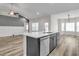 Island kitchen featuring stainless dishwasher, sleek countertops, and gray accent cabinets at 383 Hayloft Circle, Conway, SC 29526